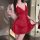 A woman poses elegantly in a red lace slip dress, holding a glass of water. the dress features delicate lace detailing and ad...