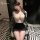 Woman wearing yaqin nu lingerie set with lace top and bodycon skirt, seated on chair in stylish room.