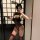 Woman in yaqin nu lace open-crotch nightgown with bunny ears, holding phone and whip—sensual date-night lingerie.