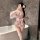 Woman in pink floral yaseyese kimono-style lingerie set with bow, sheer sleeves, and thigh-highs, posing in bathroom mirror.