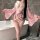 A woman stands beside a bathtub wearing a pink yasise kimono-style lingerie set, featuring floral patterns and a bow detail, ...