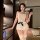 A woman models a yasu sexy lingerie set featuring a pearl-embellished backless bodysuit with lace detailing and a black bow a...