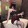 A woman sits on a bathtub wearing a black and red new year pure & tempting lingerie skirt, adorned with rose details and shee...