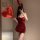 A woman poses in a red halter bunny costume with sparkling sequins, holding a heart-shaped balloon. perfect for cosplay or li...