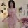 A woman models a delicate pink sleep dress with a bow detail, paired with elegant floral accents and a sophisticated design, ...