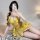 A woman poses seductively wearing a yellow lace bodysuit set, featuring floral patterns and a plunging neckline, perfect for ...