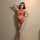 Woman modeling orange yeqingge lace bodysuit set with sheer mesh crop top and high-waisted briefs, elegant floral jacquard de...