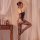 Woman wearing yeqingge sheer lace bodysuit with bow detail and floral jacquard stockings, posing elegantly beside vintage nig...