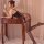 Woman in yeqingge sheer lace bodysuit with bow detail and floral jacquard stockings, posing at vanity with hand mirror.