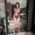 Woman modeling yese yese purple mesh bodysuit with floral cut-outs, sheer bra and panty set, in modern marble bathroom.