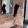 A woman stands by a bathroom sink wearing a white cami dress adorned with playful cat prints. the dress features a built-in p...