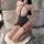 Woman kneeling in bathroom wearing yesiyesi sexy lace bodysuit with halter neck, sheer polka-dot tights, and open-back design...