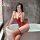 Woman in red yeyu lace lingerie set with underwire, padded cups, and fishnet stockings posing by a bathtub.