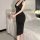 A woman stands beside a bed wearing a black yilanfang new bride cheongsam lingerie dress, featuring a deep v neck and halter ...