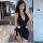 A woman poses in a stylish black dress featuring a plunging neckline and side cutouts, perfect for evening wear or live strea...