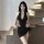 A woman wearing a black yingqing sexy lingerie set, featuring a backless bodycon bandage dress with adjustable straps, perfec...