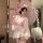 A woman poses elegantly in a pink japanese kimono-inspired costume, complete with bunny ears and floral accents, holding an o...