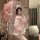 A woman poses elegantly holding a delicate parasol, wearing a soft pink japanese kimono-inspired costume with bunny ears. per...