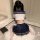 A girl wearing a navy blue and white sailor-style school uniform sits on a fluffy rug indoors, with a book beside her. the ou...