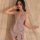 Woman wearing shiny pink yue die deep v-neck bodycon nightgown, posing softly by sheer curtains for intimate or nightclub wea...