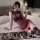 Woman in yuedie ol-style bodycon dress with lace stockings, holding wine glass on bed.
