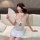 A woman wears a sheer white zhongqu sensual lace cheongsam lingerie, featuring lace details, ties, and cut-out designs, holdi...