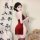 A woman poses elegantly in a zimei red silk velvet chinese-style lingerie set, featuring traditional knotted buttons and shee...