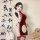 A woman poses elegantly in a zimei red silk velvet chinese-style lingerie set, featuring traditional knotted buttons and shee...