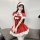 A woman wears a festive red dress with white fur trim, featuring a santa hat and bow tie, perfect for holiday celebrations.