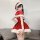 A woman poses wearing a festive red dress with white fur trim, santa hat, and stockings, embodying a christmas holiday romant...