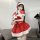 A woman poses wearing a festive red dress with white fur trim, santa hat, and stockings, perfect for holiday-themed outfits.